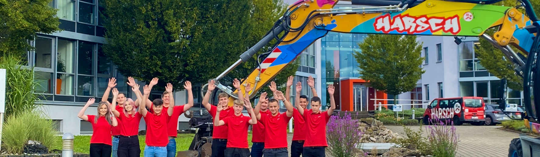 Gruppenfoto vor Bagger und Firmengebäude