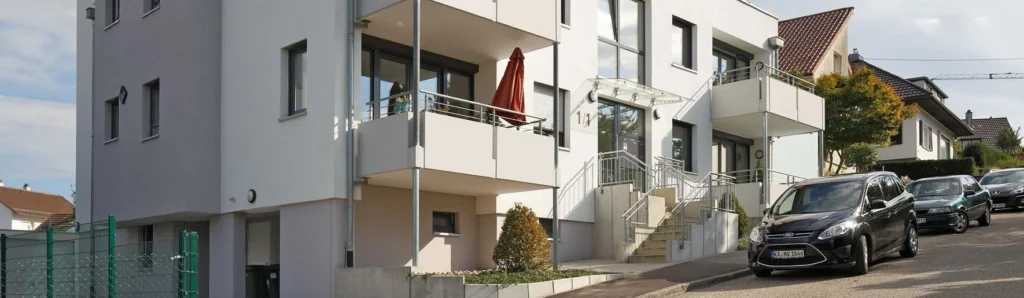 Mehrgeschossiges Wohngebäude an einer Straße mit Balkonen und Treppenanlagen